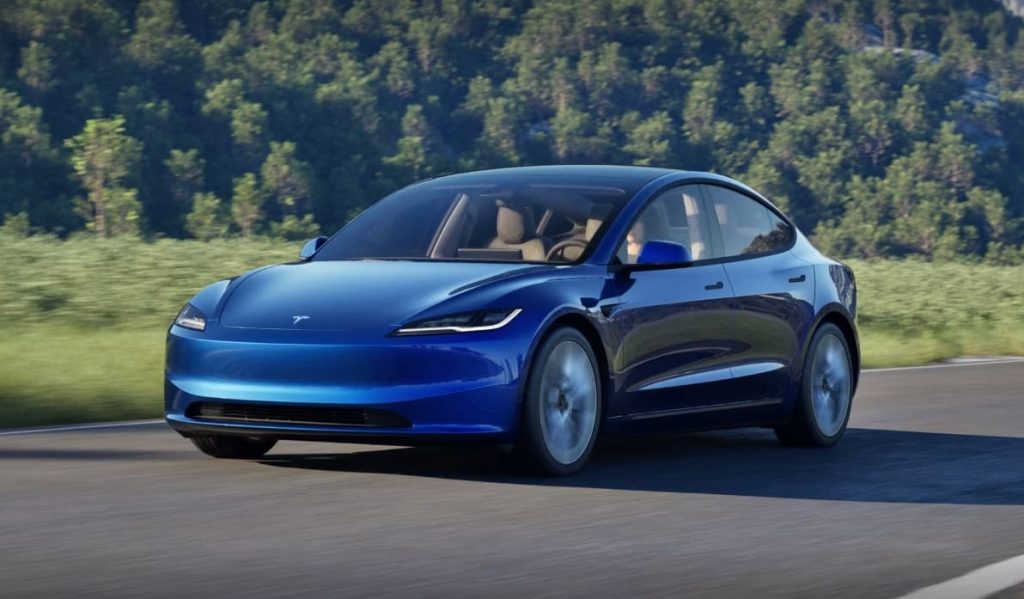 Bild på en Tesla Model 3 med skog i bakgrunden.