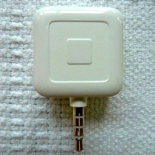 Square brand credit card payment device on white cloth background
