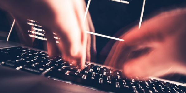 hands quickly typing on a laptop computer keyboard