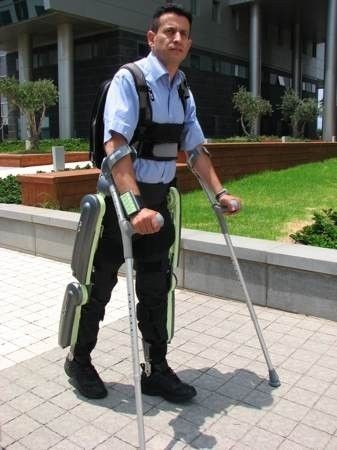 man using ReWalk exoskeleton with crutches to walk 