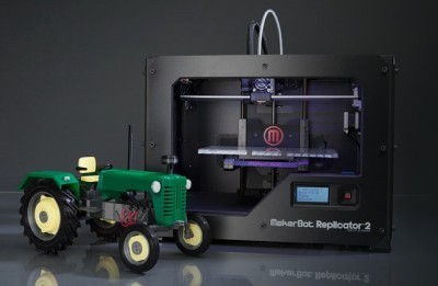 3D printed tractor model in front of Makerbot Replicator 2 3D printer