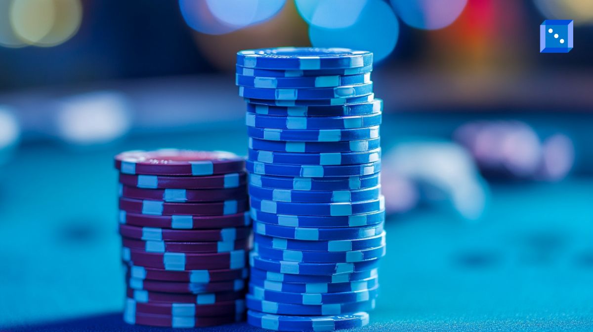A close-up view of neatly stacked blue and red poker chips on a casino table, illuminated by vibrant blue and purple bokeh lights in the background. The scene captures the high-stakes atmosphere of gambling, evoking themes of risk, fortune, and strategy in casino gaming.