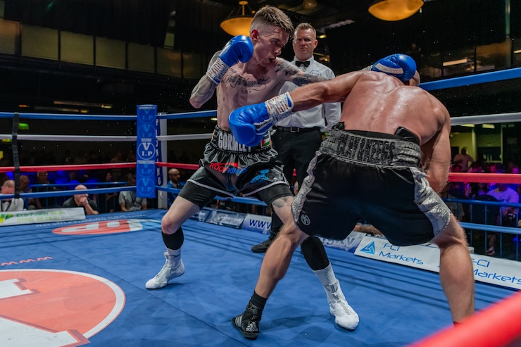 Lee Gormley prepares to throw a punch while another boxer bends forward in the match.