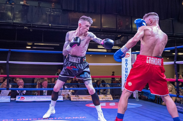 Lee Gormley and his opponent engage in a match in a ring.