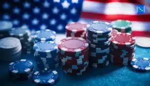 Stacks of colorful poker chips, with a blurred American flag in the background