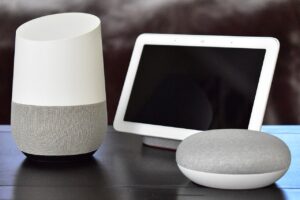 Google Home smart speaker, smart display, and smart speaker on a table