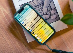 An iPhone showing its Notification Center screen on top of a book.