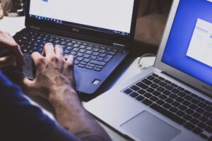 Person using two laptops at a desk