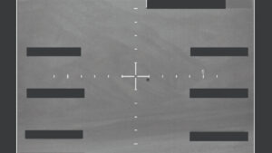 A military photograph depicting an unidentified speck in the sky.