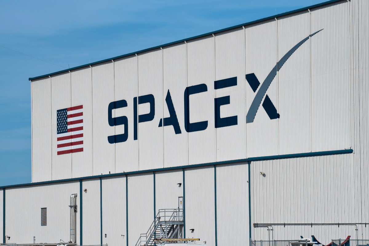 SpaceX headquarters building with large company logo and American flag displayed on exterior following record-breaking Nasdaq IPO debut
